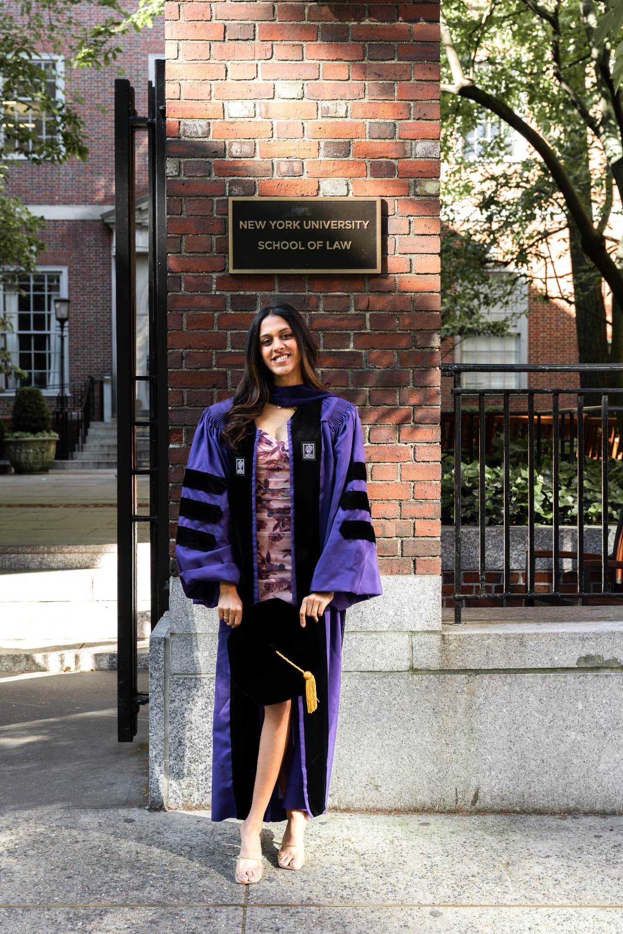 Sanjana Saxena in NYU School of Law graduation regalia, holding her cap